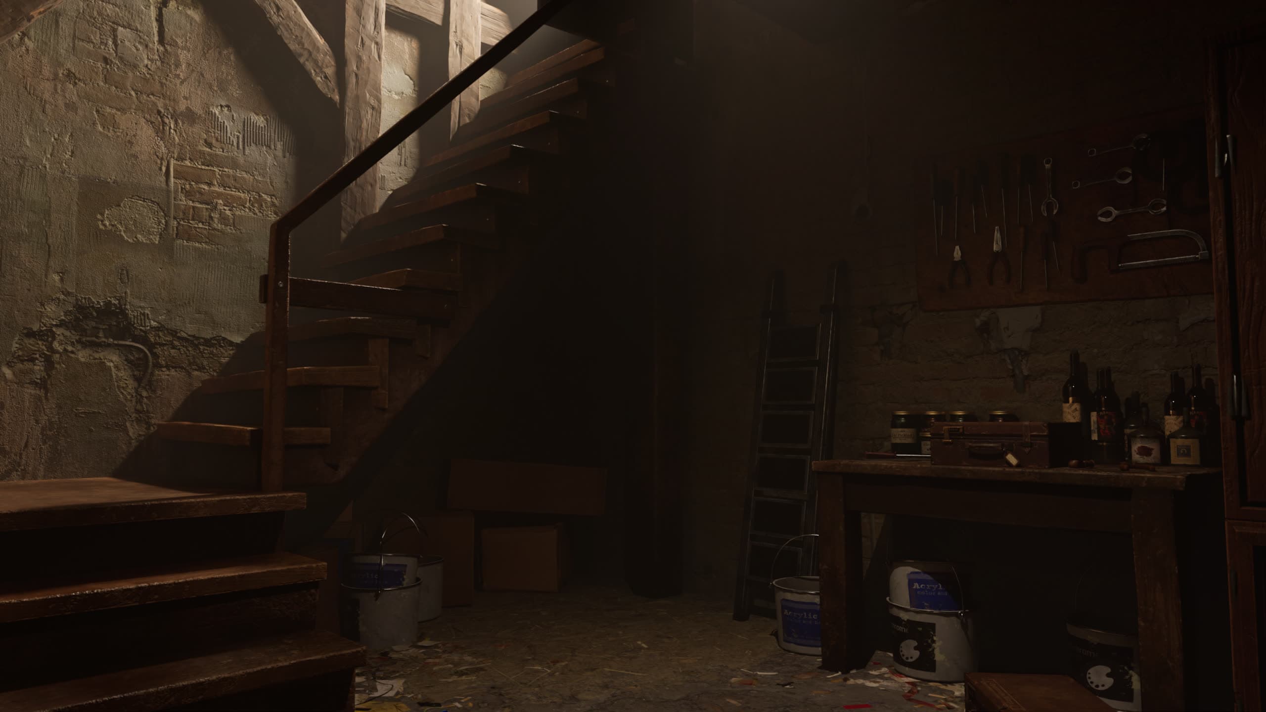 Dim basement with wooden stairs, a tool wall, and a workbench under a shaft of light